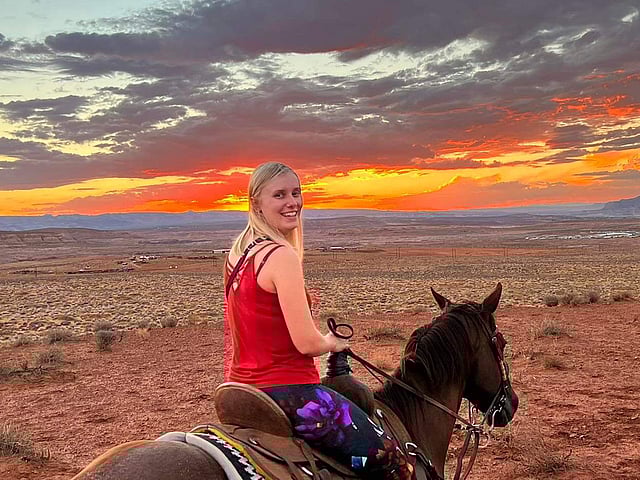 A person riding a horse in the desert.
