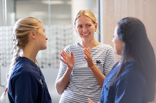 A group of women in scrubs talking.